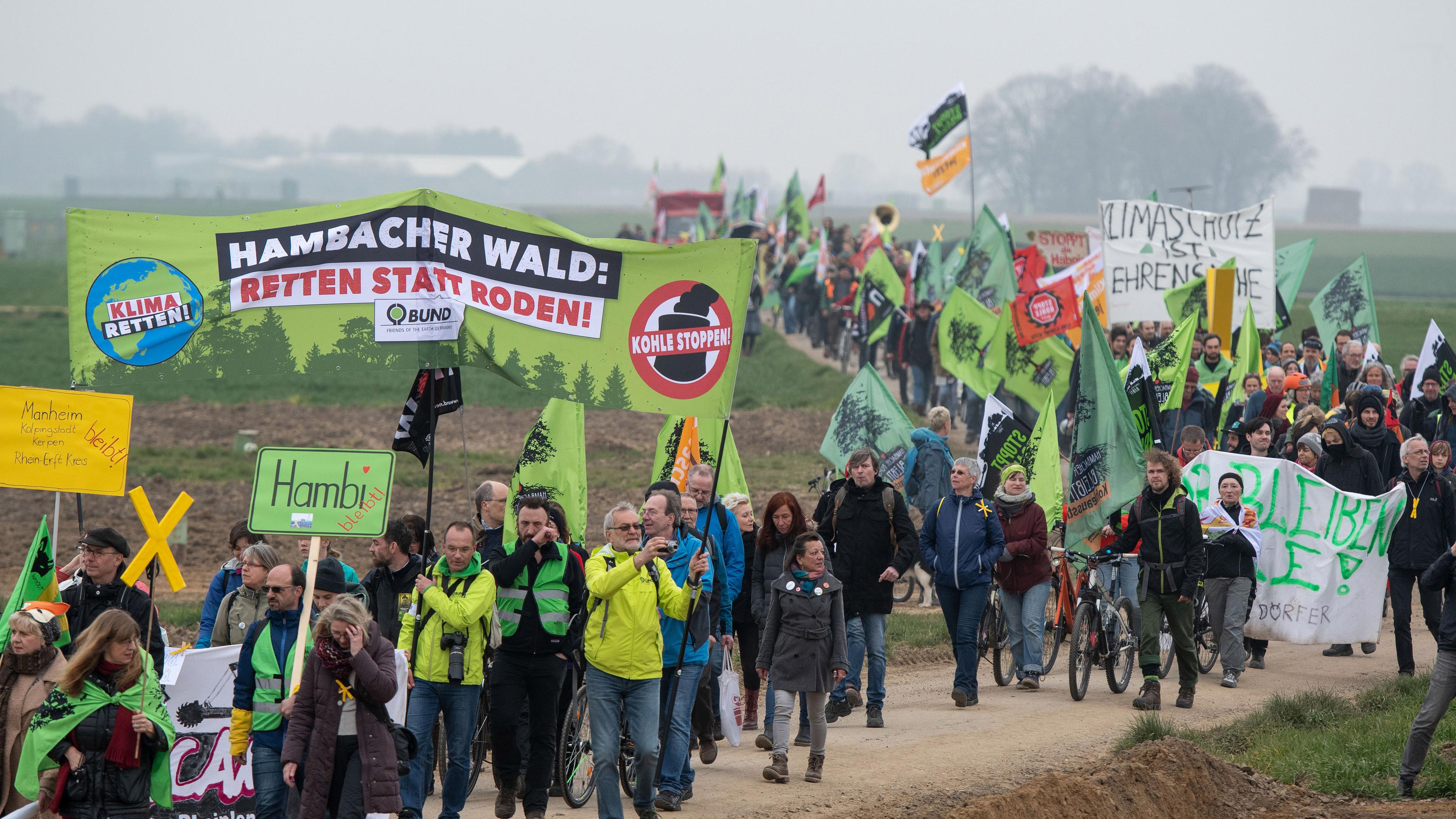 Eine Demonstration mit vielen Menschen. Auf einem Banner ist zu lesen: "Hambacher Wald – Retten statt roden".