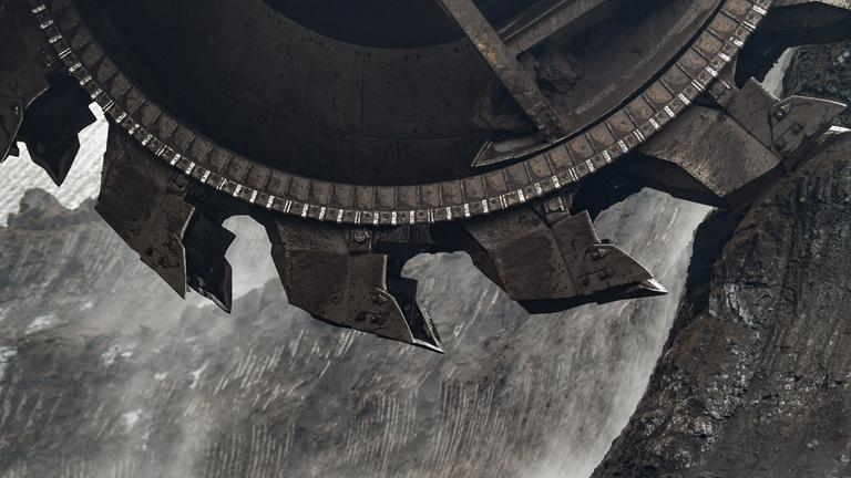 Eine Braunkohleschaufel nimmt Erdreich auf.