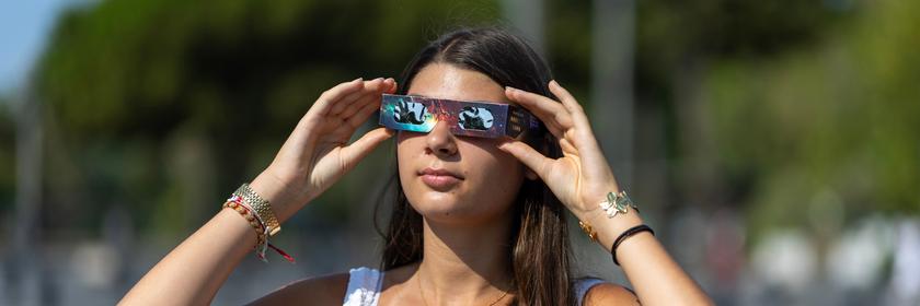 Eine Person richtet ihre Finsternisbrille zurecht. 