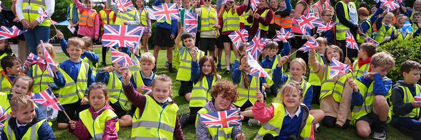 Kinder winken und halten britische Flaggen in den Händen. 