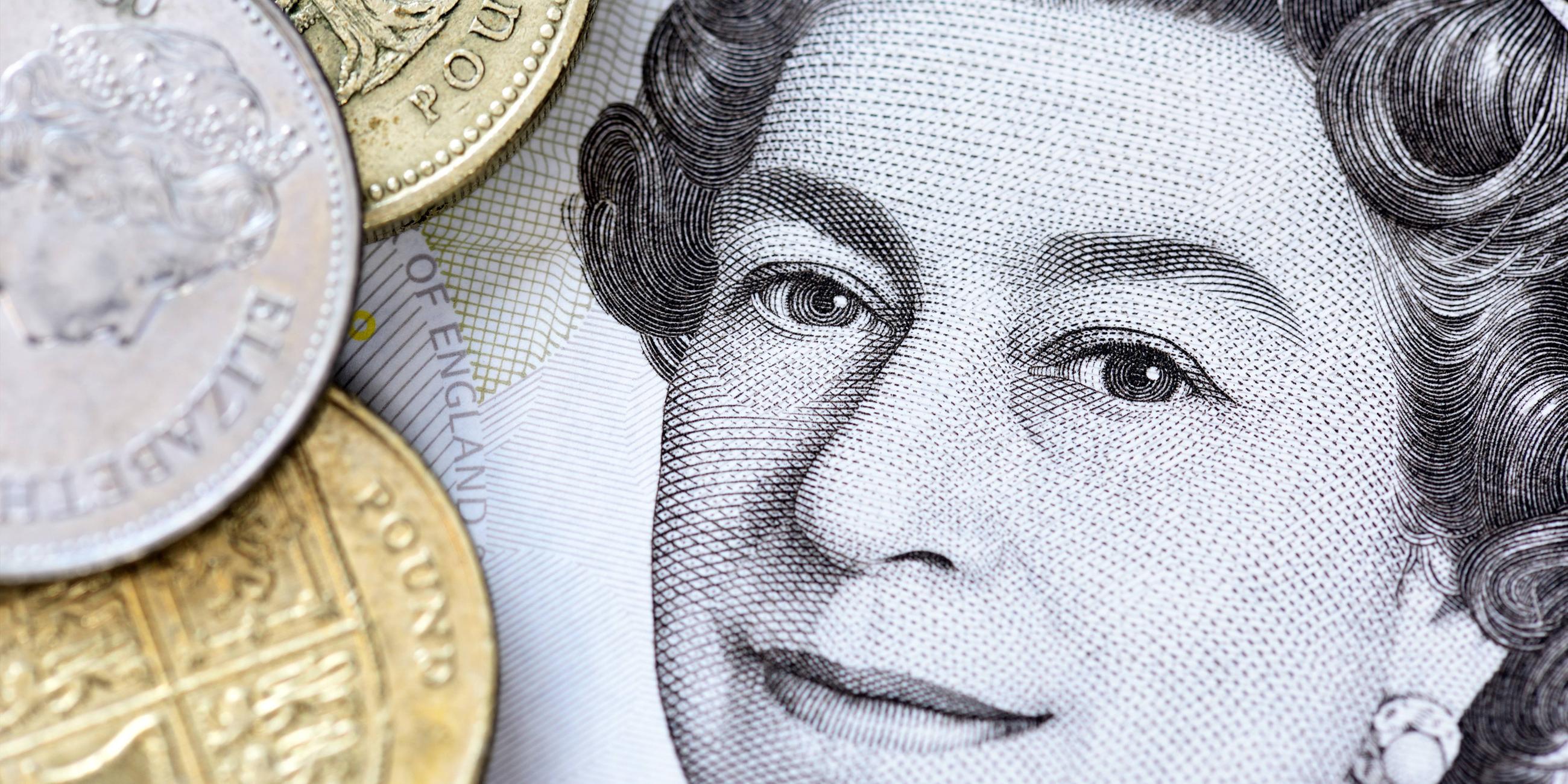 Portrait von Queen Elizabeth II. auf einer britischen Fünf-Pfund-Note und Pfundmünzen