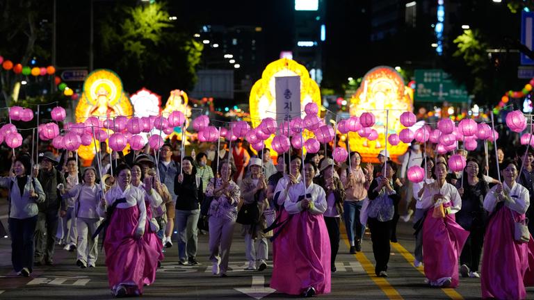 Buddhisten nehmen an einer Parade des Lotusfestivals in Südkorea teil. Sie tragen pinke Laternen.