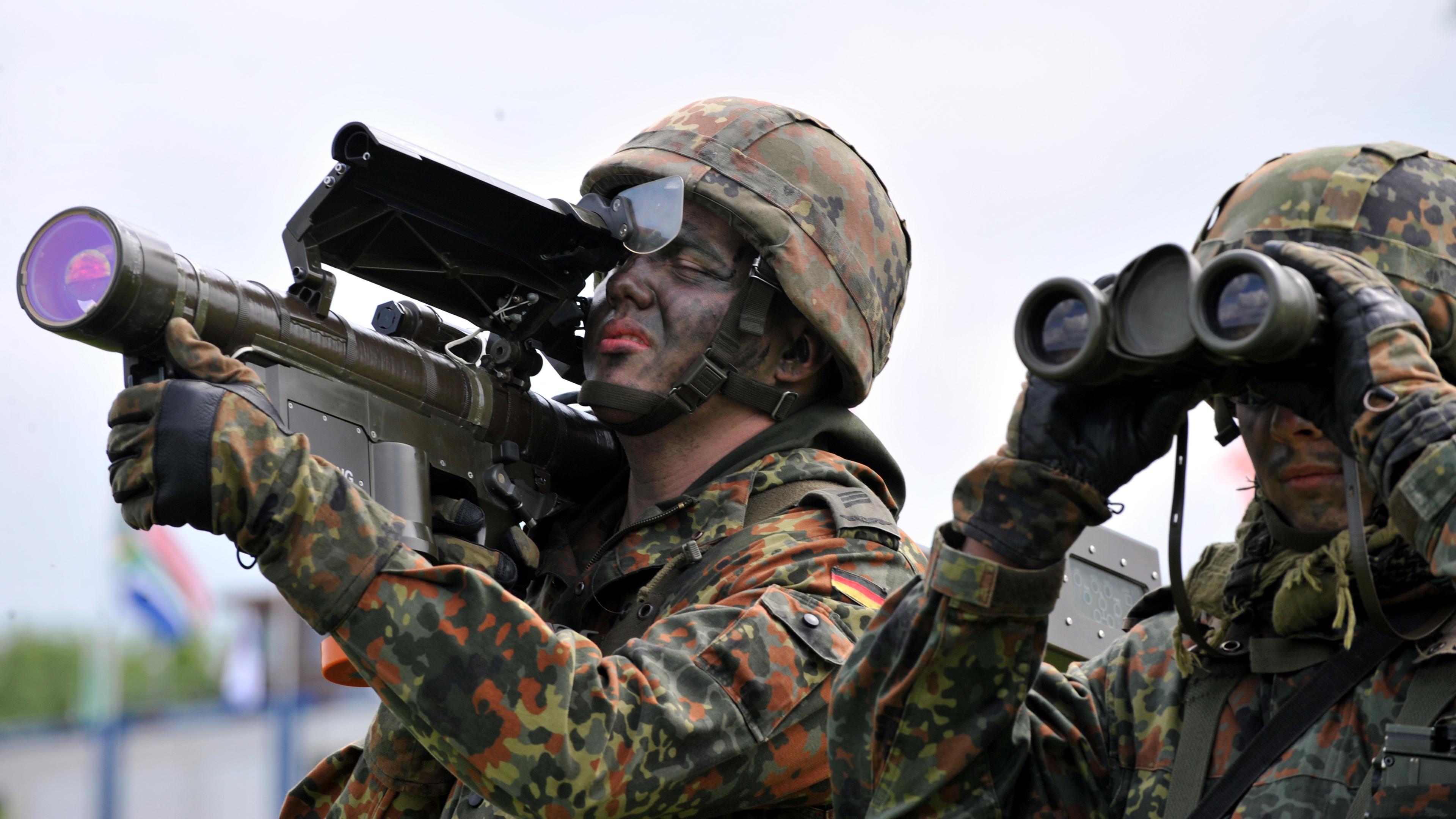 Zwei Soldaten, einer mit Fernglas, der andere hält eine Flugabwehrrakete vom Typ "Stinger". 