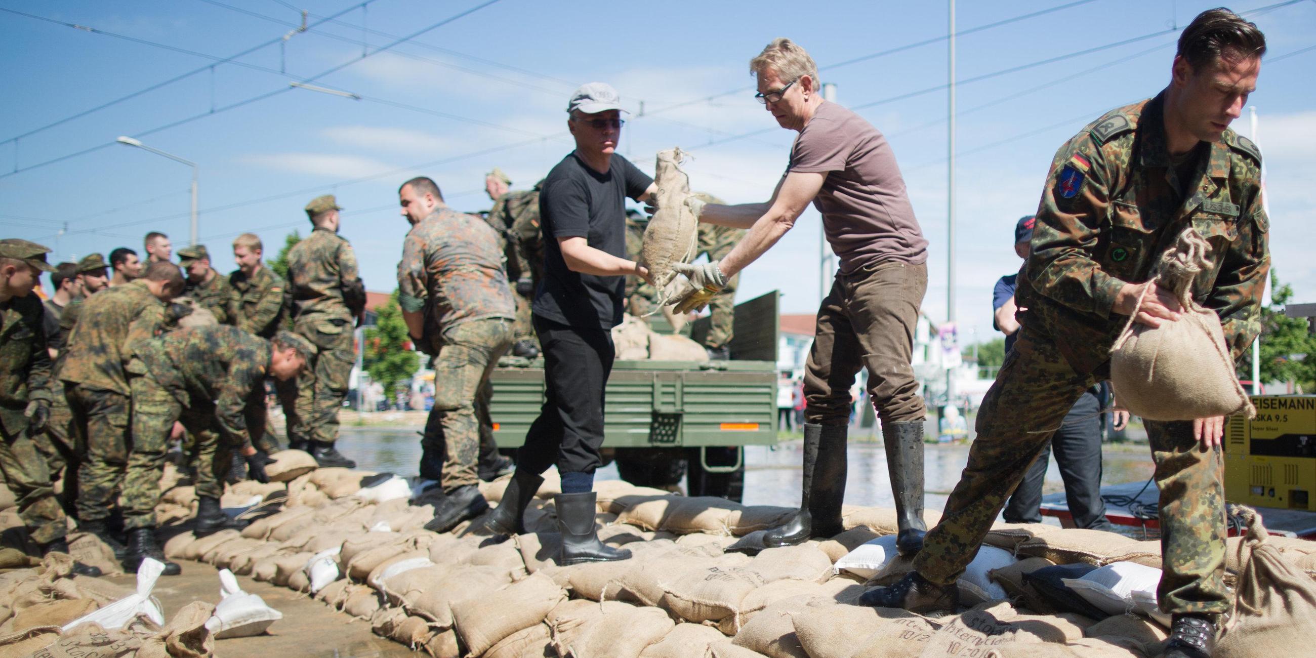 Bundeswehrsoldaten schichten Sandsäcke zum Schutz vor Hochwasser