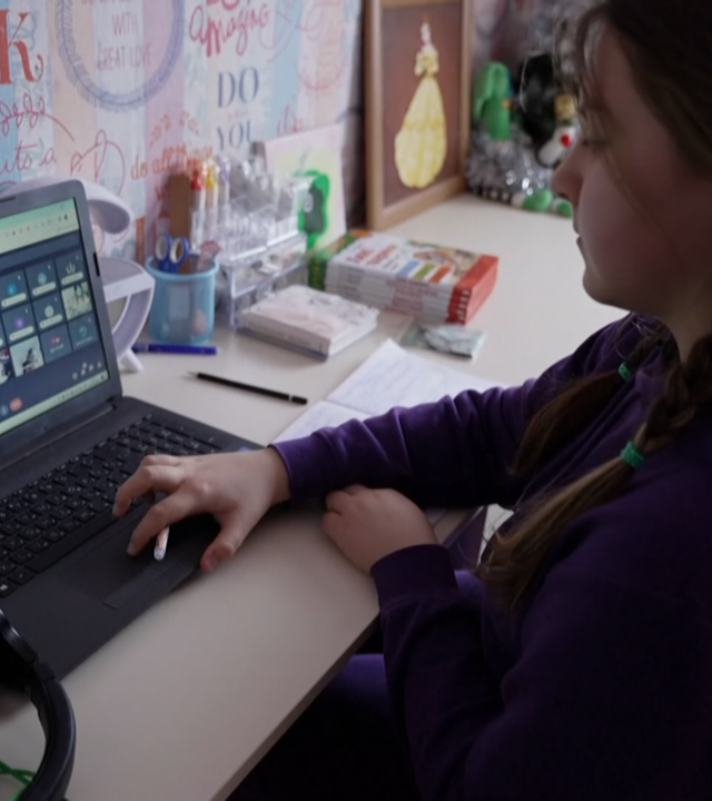 Mädchen sitzt am Laptop und mach Homeschooling