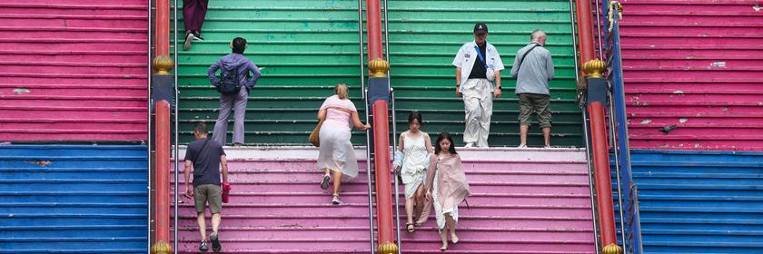 Menschen auf einer bunt angemalten Treppe.