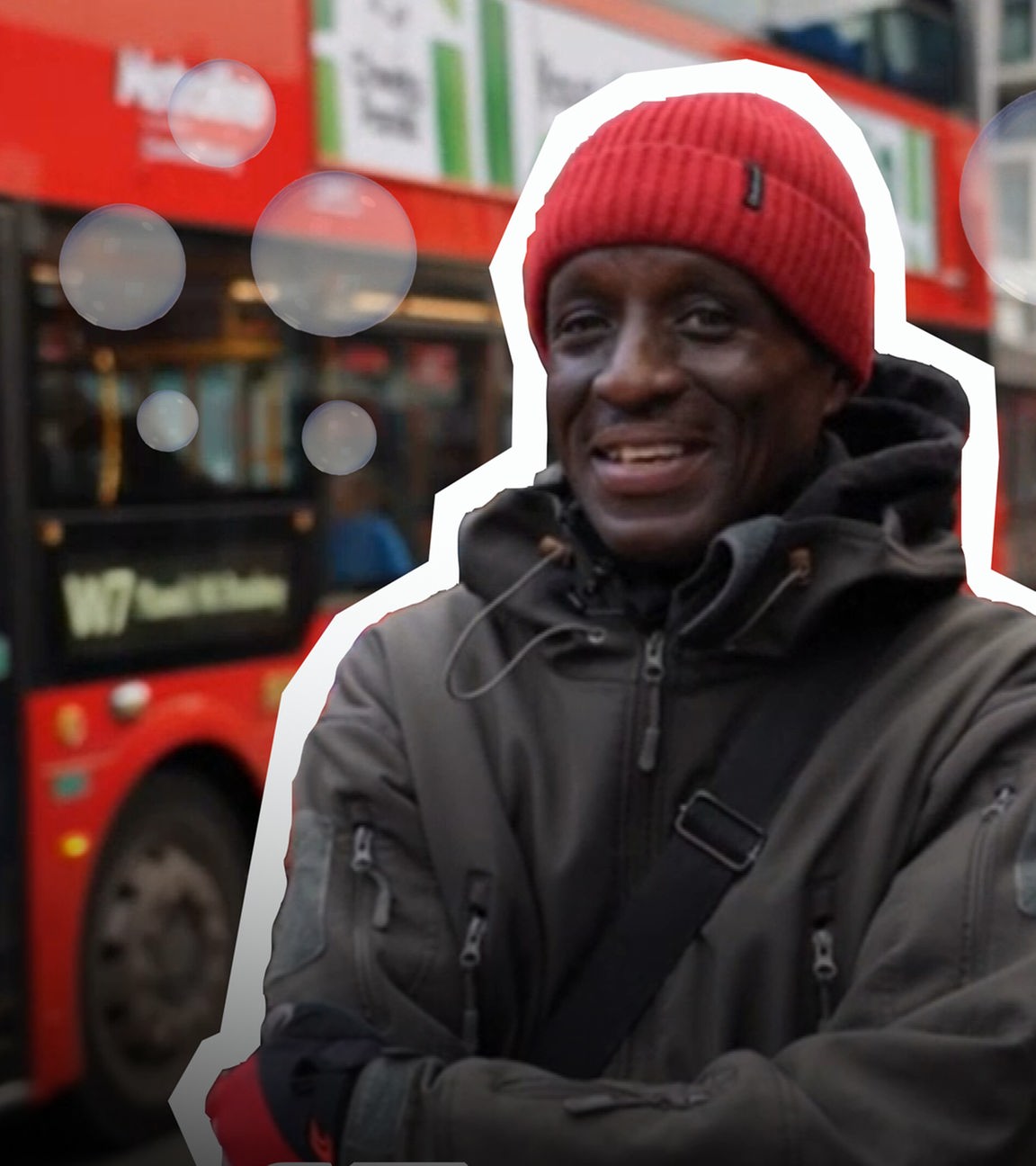 Ein Busfahrer steht mit einer Seifenblasen-Kanone in einer Wolke Seifenblasen vor einem Bus