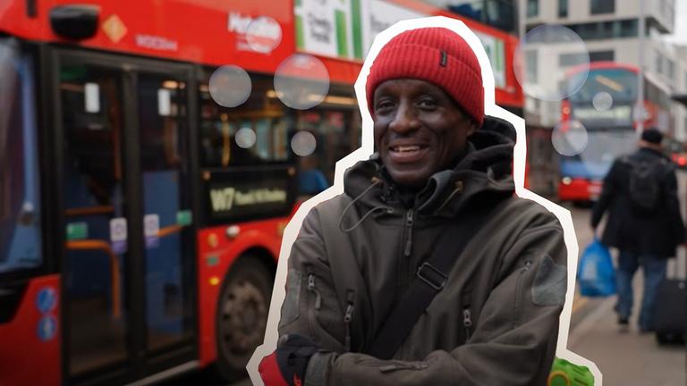 Ein Busfahrer steht mit einer Seifenblasen-Kanone in einer Wolke Seifenblasen vor einem Bus