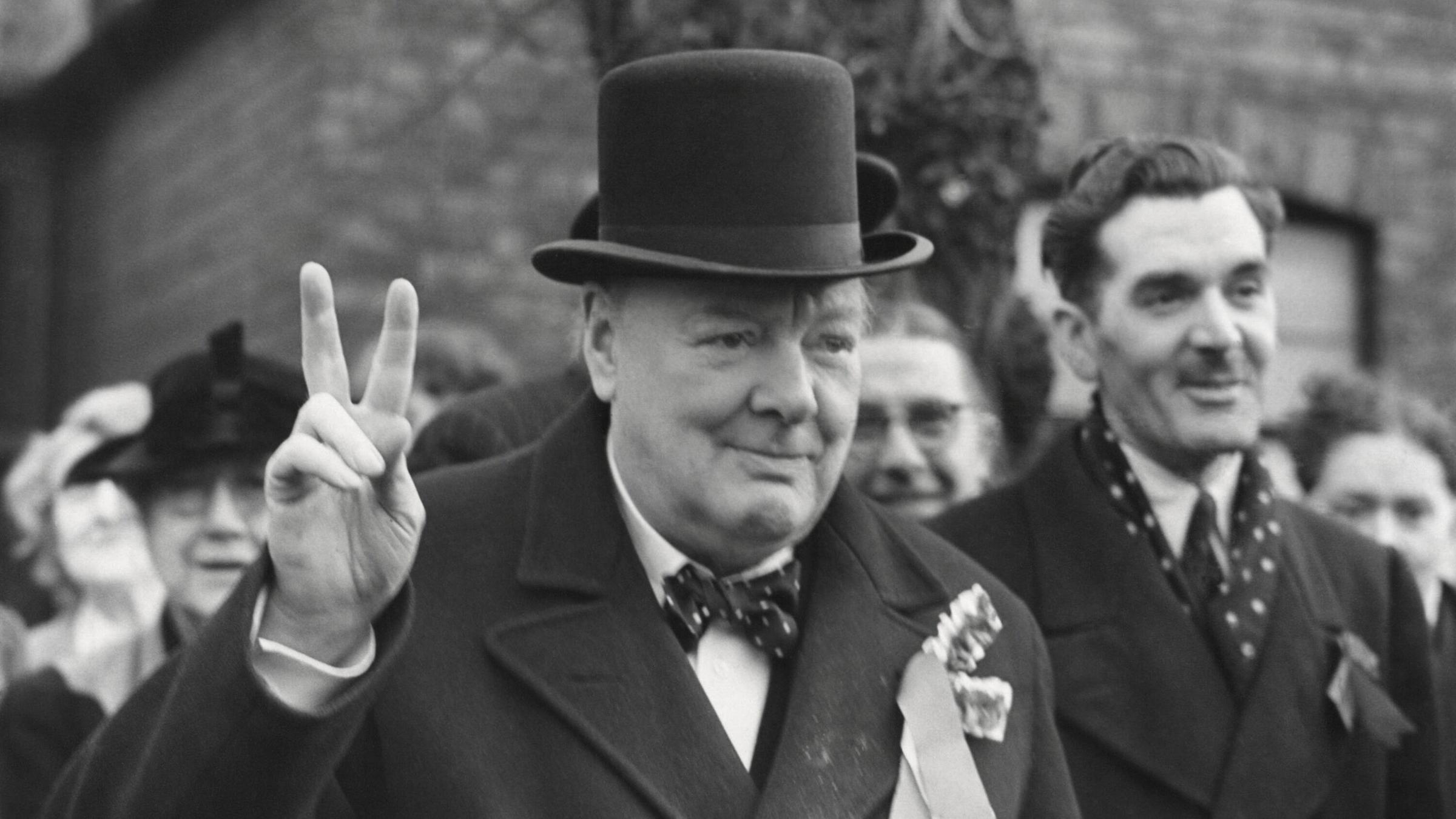 Der britische Premierminister Winston Churchill zeigt das Finger-V. 