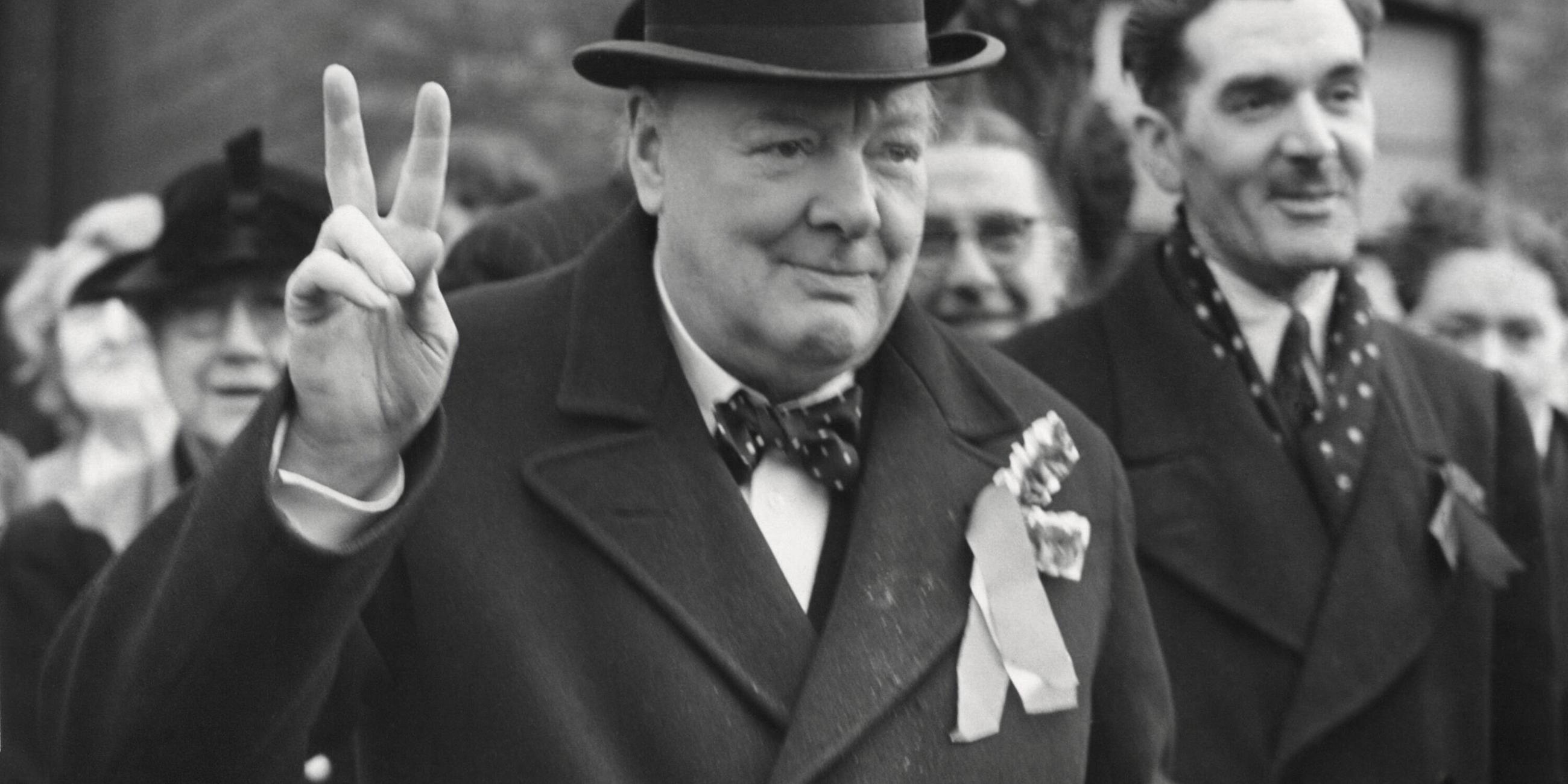 Der britische Premierminister Winston Churchill zeigt das Finger-V. 