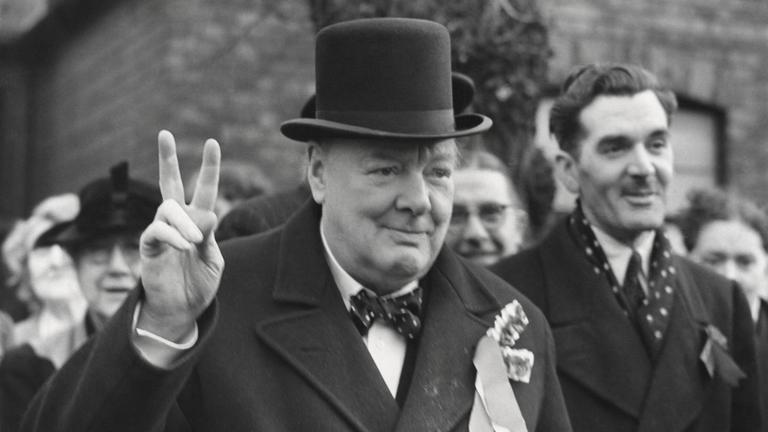 Der britische Premierminister Winston Churchill zeigt das Finger-V. 