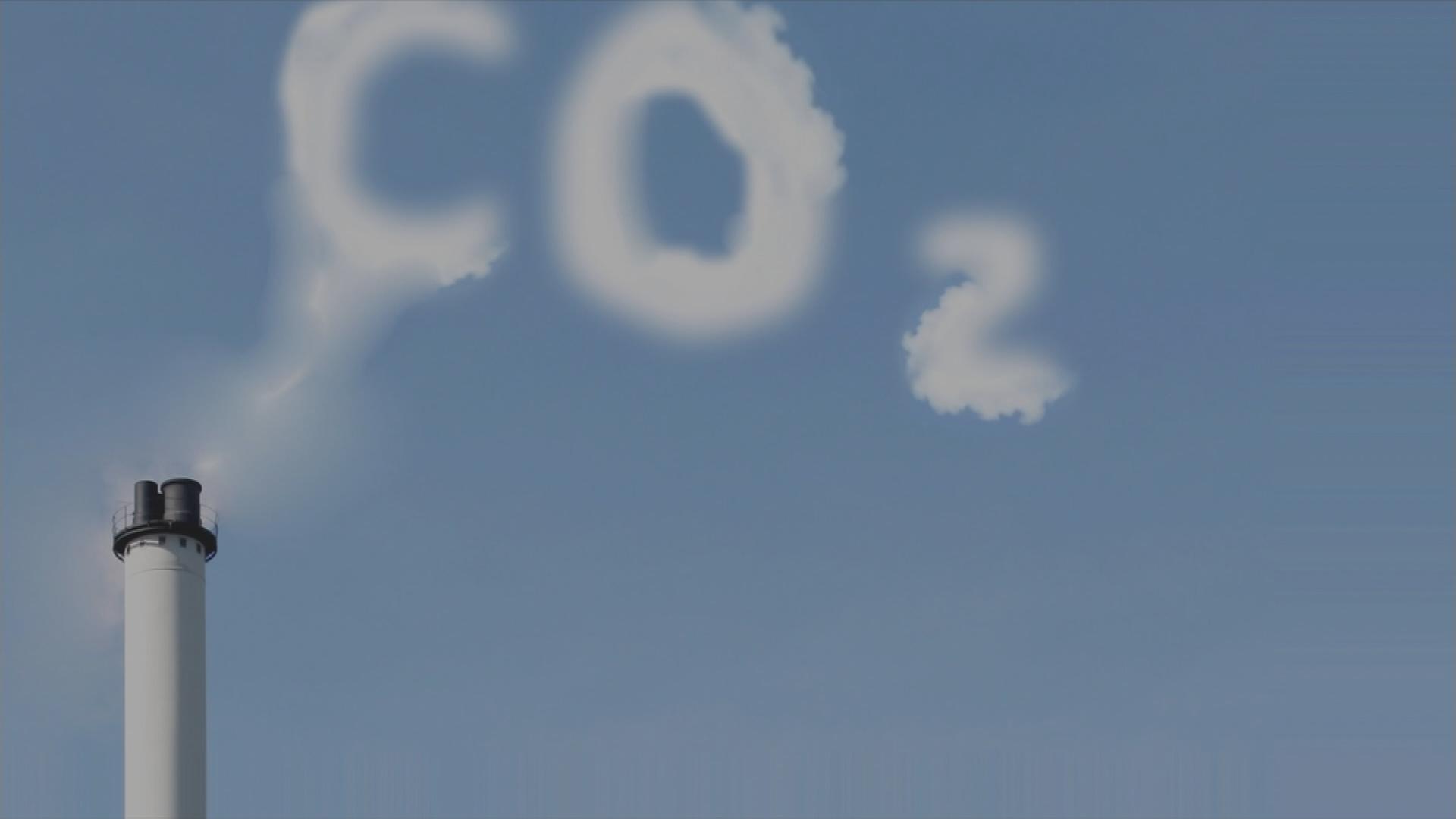 Industrieschornstein aus dem Rauch rauskommt, der CO₂ in den Himmel schreibt.