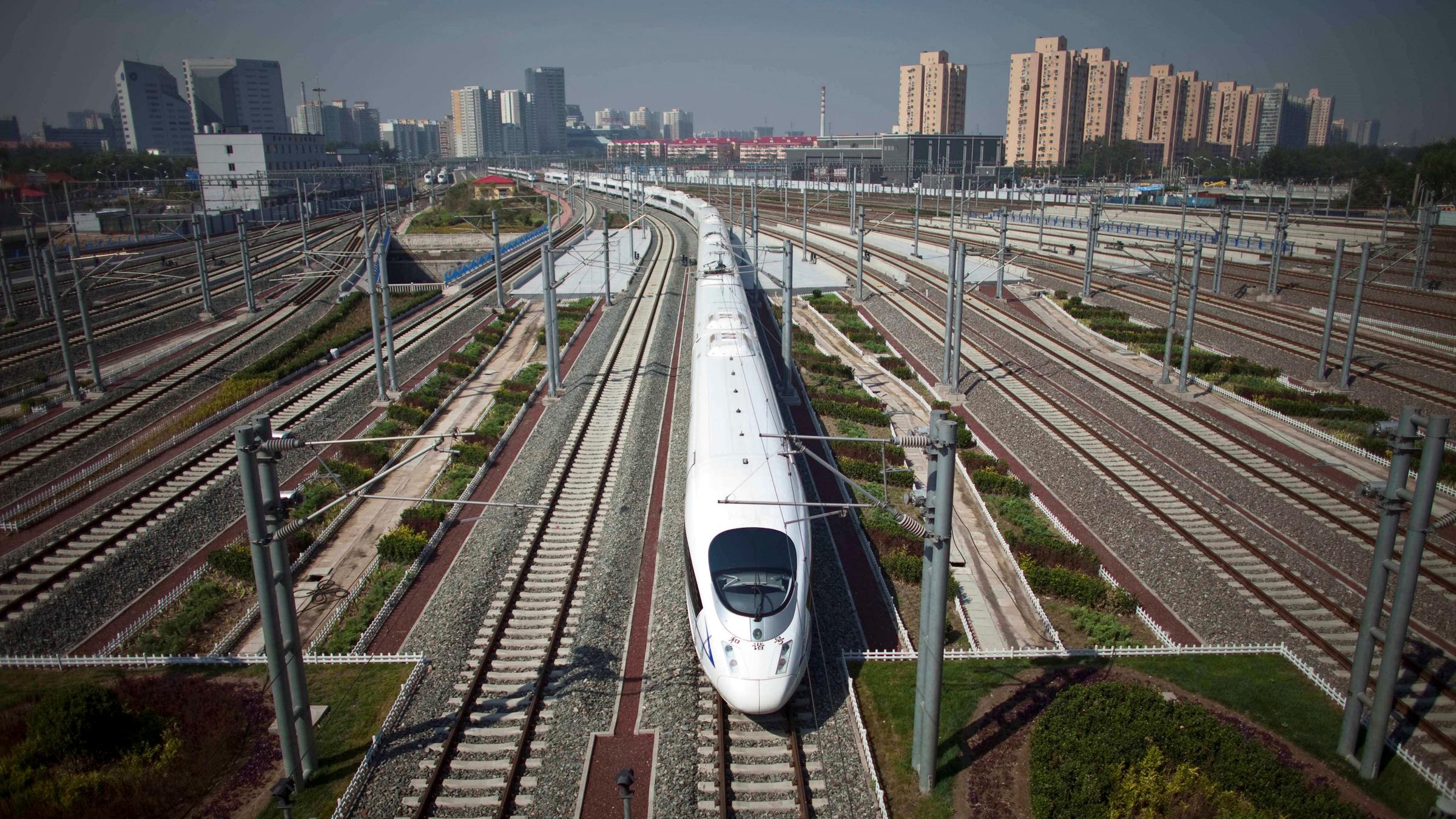Der CRH fährt in China über viele Weichen. Im Hintergrund sieht man Hochhäuser.