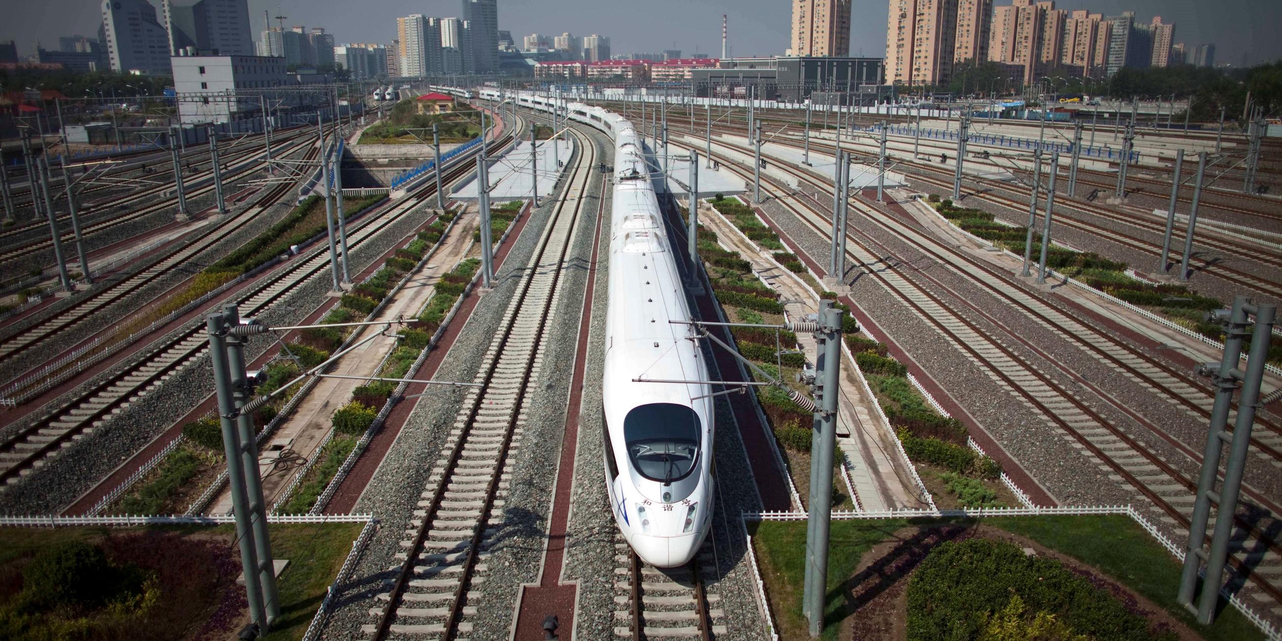 Der CRH fährt in China über viele Weichen. Im Hintergrund sieht man Hochhäuser.