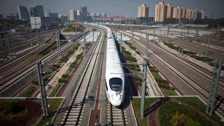 Der CRH fährt in China über viele Weichen. Im Hintergrund sieht man Hochhäuser.