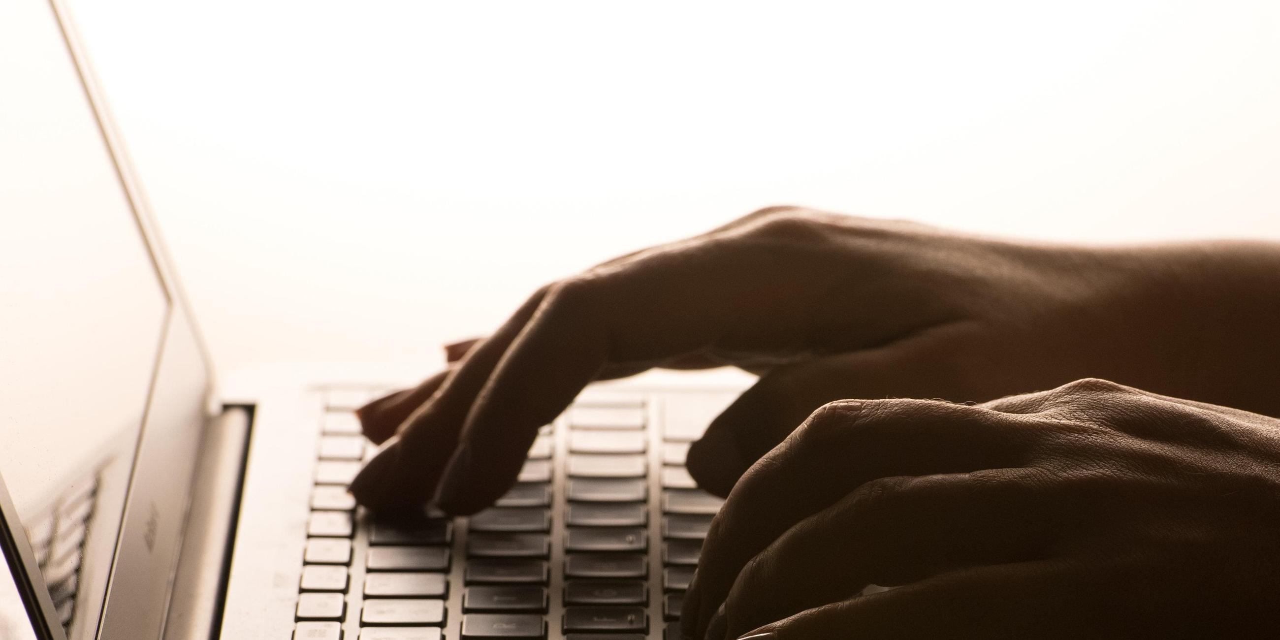 Jemand tipps auf einer Laptop-Tastatur