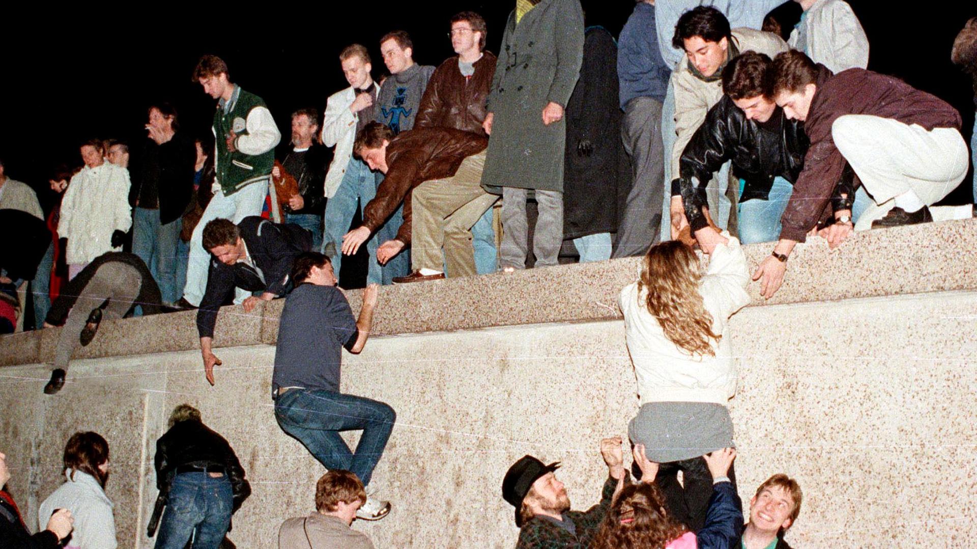 DDR-Bürger klettern am 9. November 1989 auf die Berliner Mauer