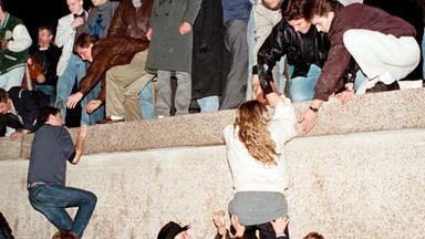 DDR-Bürger klettern am 9. November 1989 auf die Berliner Mauer