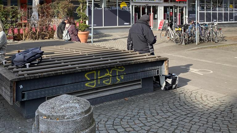 Auf großen Flachen Fläche wurden runde Rohre angebracht, sodass man hier nicht richtig sitzen oder liegen kann. 