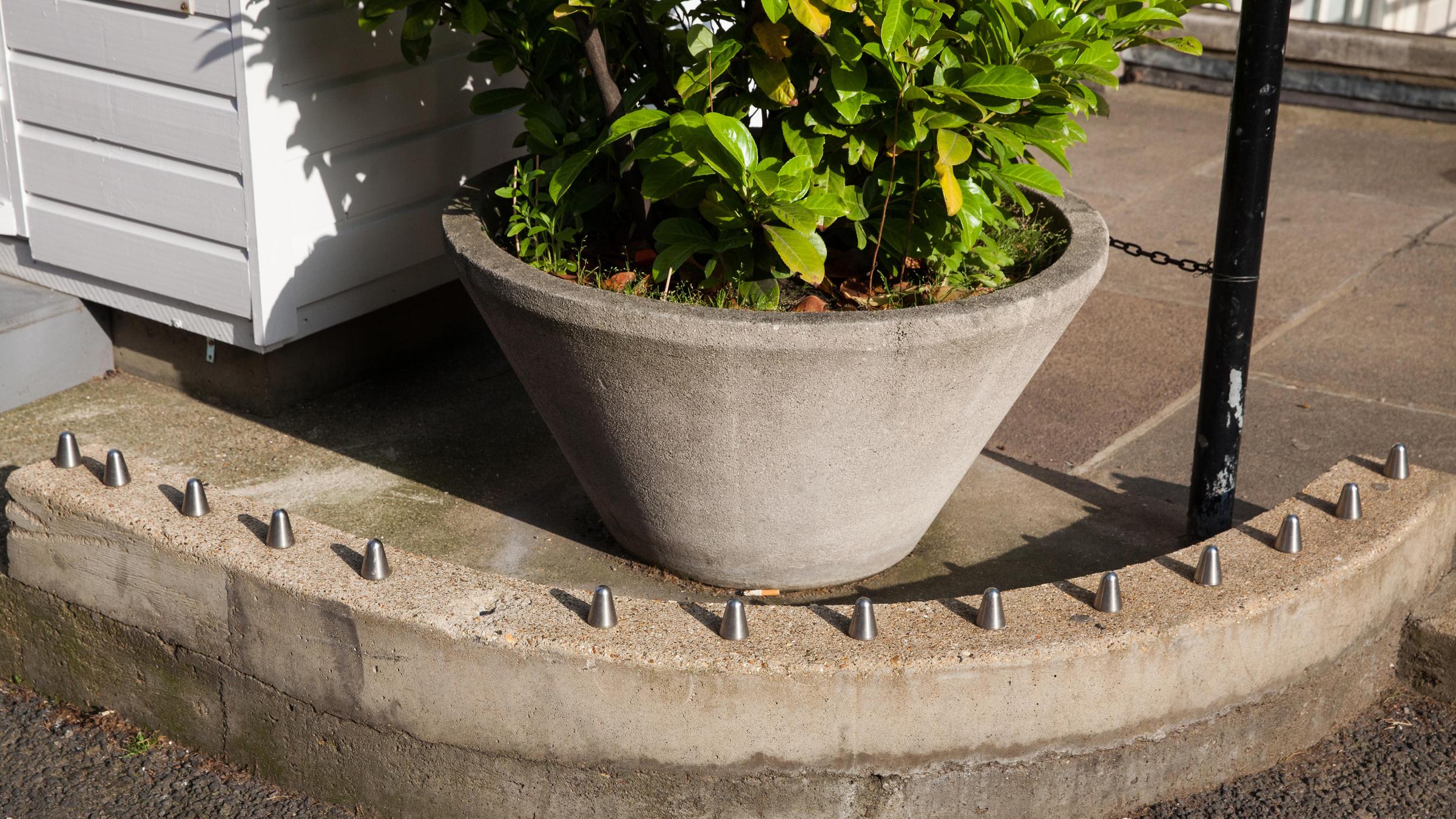 Auf einer Mauer sind Metallspitzen zum Schutz vor Obdachlosen angebracht. 