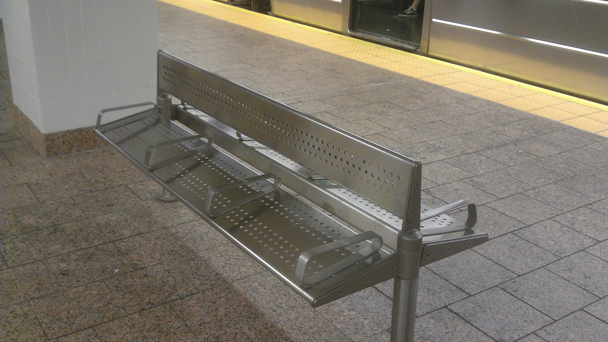 Eine Bank mit Armlehnen in einer U-Bahn-Station in New York City. 