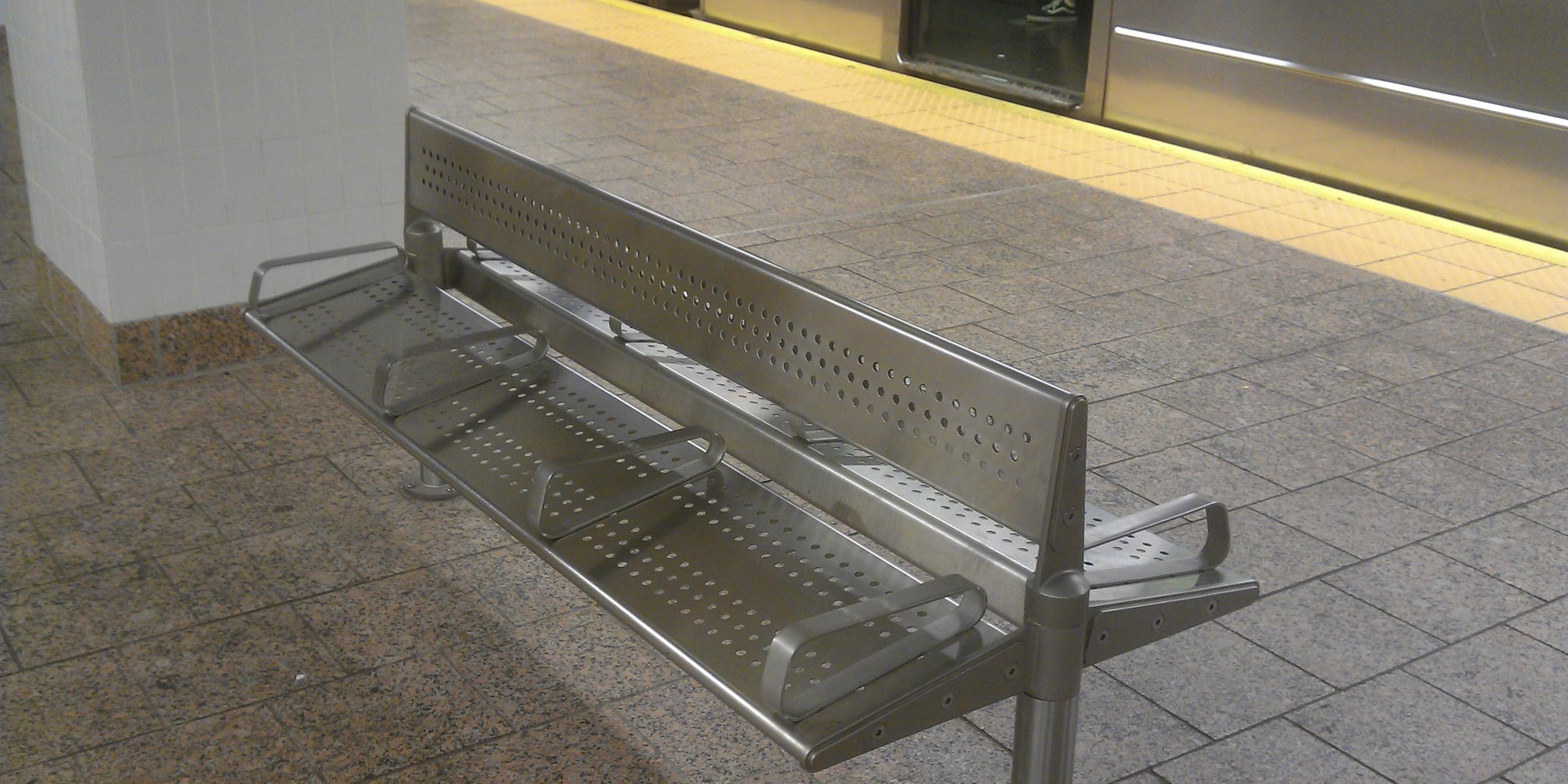 Eine Bank mit Armlehnen in einer U-Bahn-Station in New York City. 