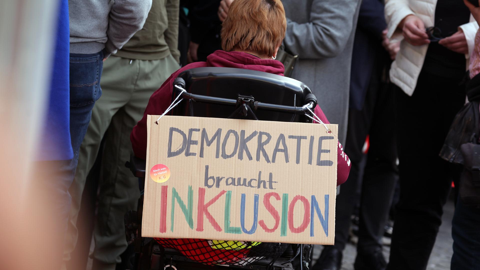 "DEMOKRATIE braucht INKLUSION" ist auf einem an einem Rollstuhl befestigten Plakat bei einer Demonstration gegen rechts in der Innenstadt zu lesen am 03.03.2024 in Würzburg.