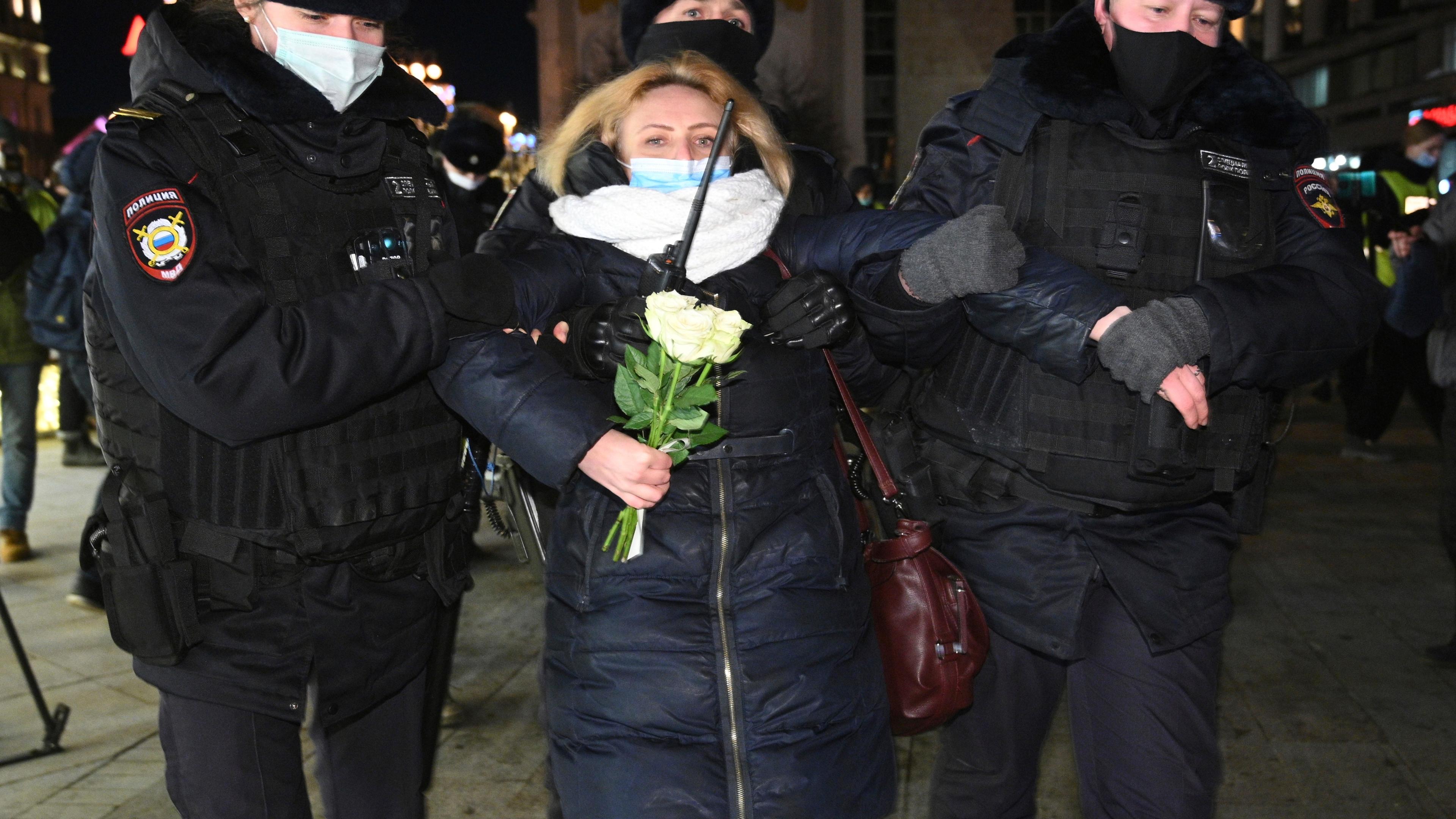 Polizisten führen Demonstrantin in Russland ab