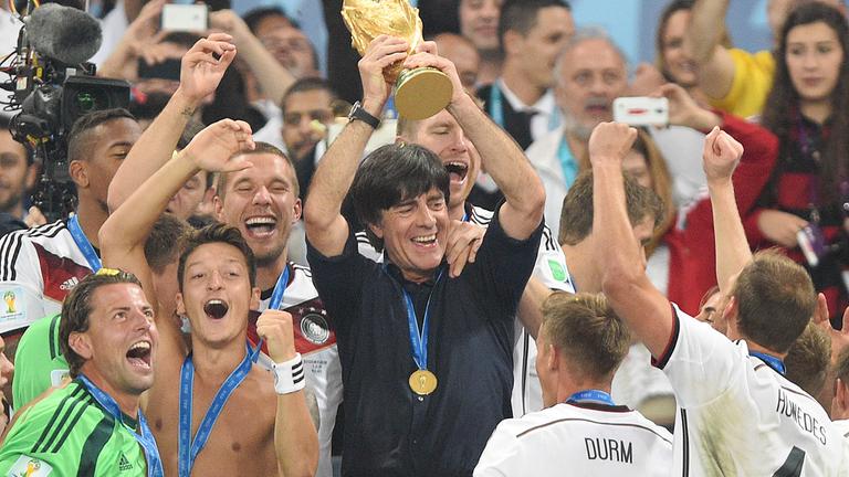 Der damalige Bundestrainer Joachim Löw jubelt mit seiner Mannschaft über den WM-Pokal. 