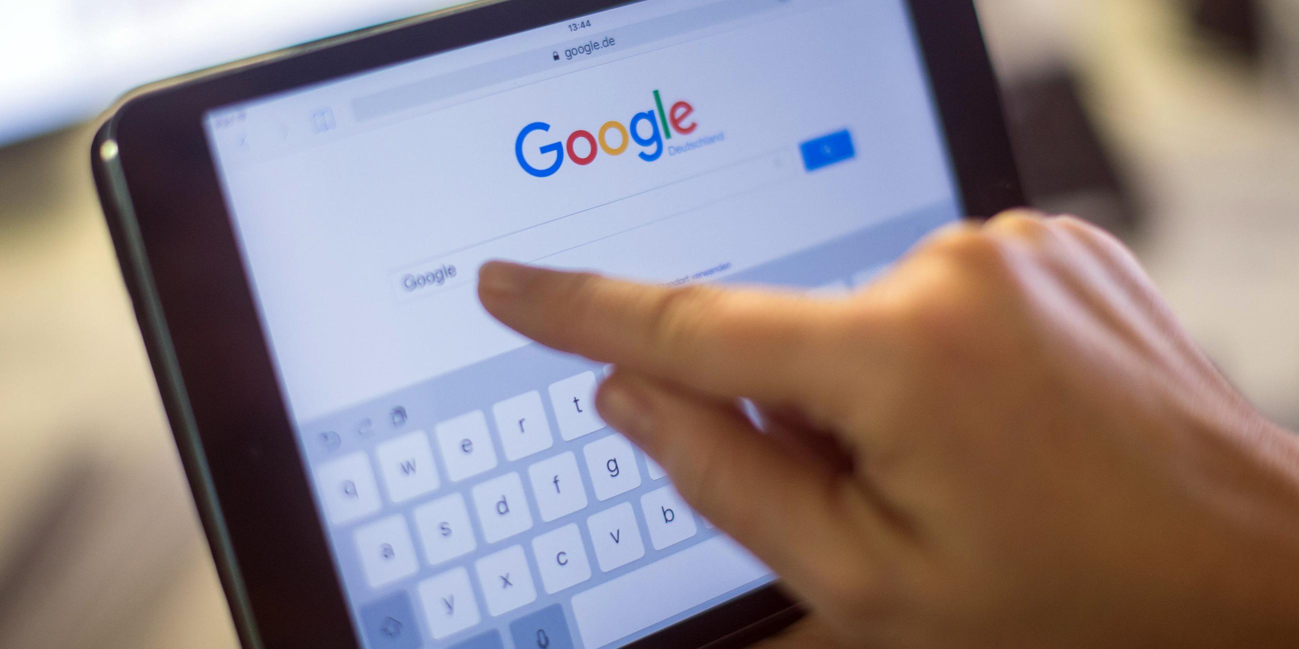 Eien Person tippt auf einem iPad Mini etwas in ein Suchfeld beim Internetdienst Google. Tech-Giganten wie Facebook und Google müssen in der Europäischen Union künftig deutlich strengere Regeln einhalten.
