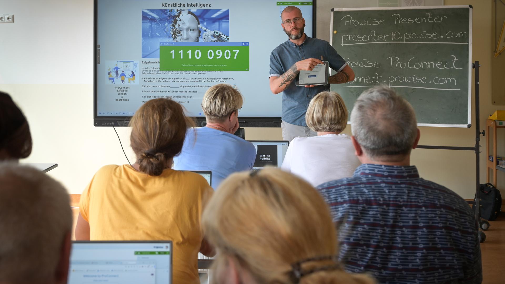Zwei Erwachsene stehen vor einer digitalen Tafel.