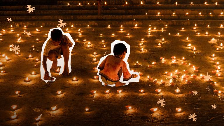 Zwei Kinder zünden viele kleine Ölllampen an.