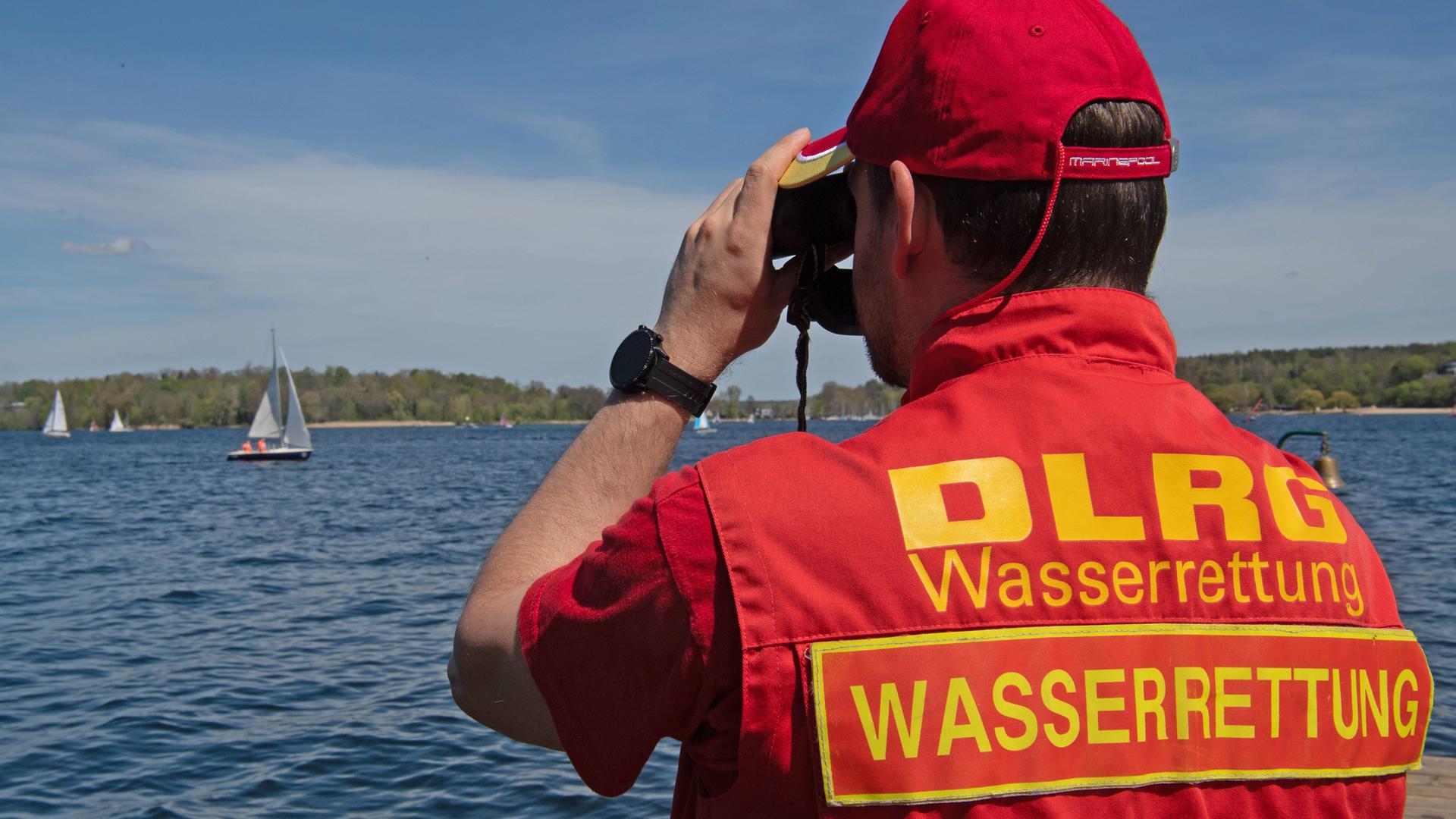 Ein Mitglied der Deutschen Lebensrettungs-Gesellschaft (DLRG) beobachtet die Boote auf dem Wannsee. 