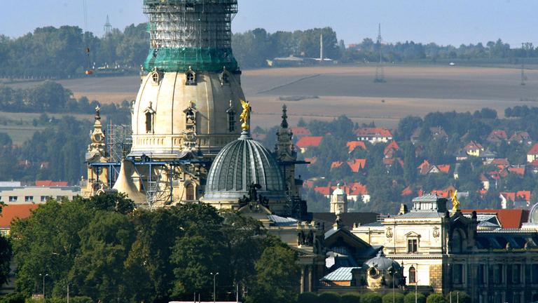Blick auf die Brühlsche Terrasse in Dresden mit der Frauenkirche und der Kunstakademie. Gerüste um die Frauenkirche werden entfernt, während der Wiederaufbau der zerstörten Kirche voranschreitet.