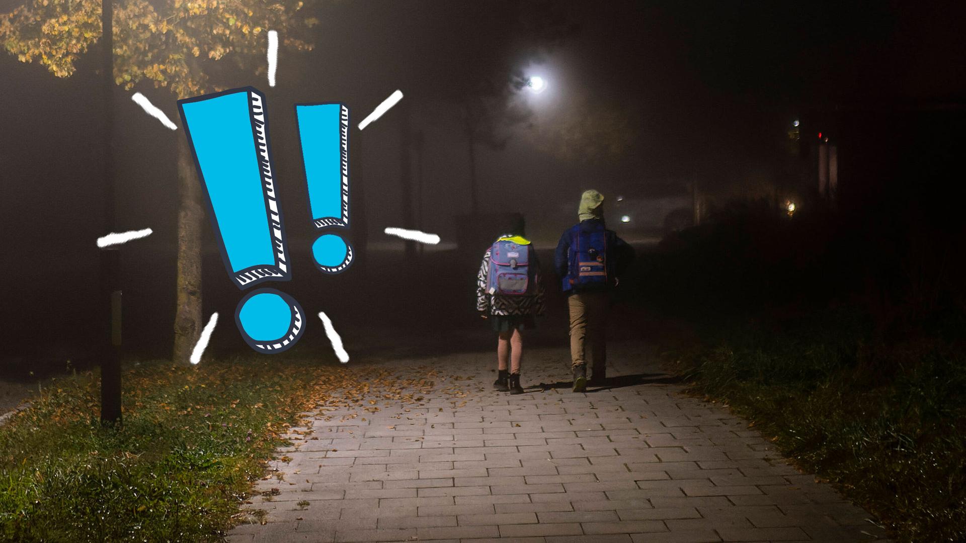 Zwei Schulkinder laufen nebeneinander im Dunkeln zur Schule, daneben zwei blaue Ausrufezeichen.
