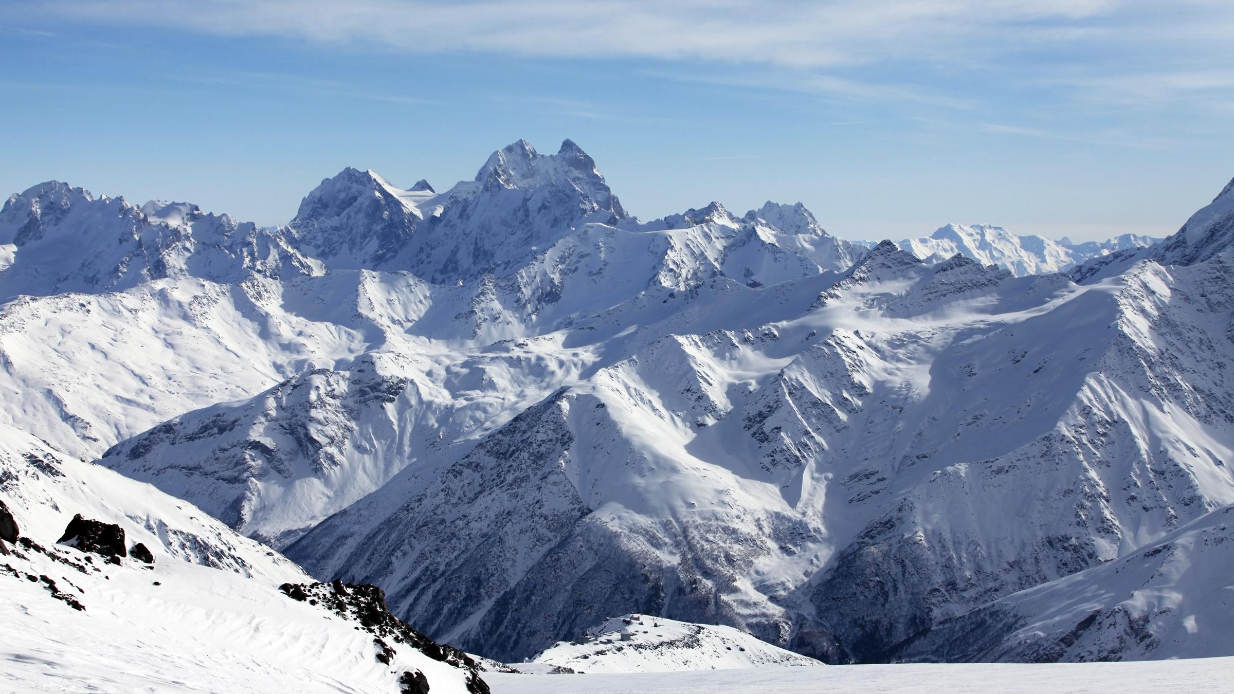 Man sieht den schneebedeckten Berg Elbrus und andere Berge im Gebirge Großer Kaukasus.
