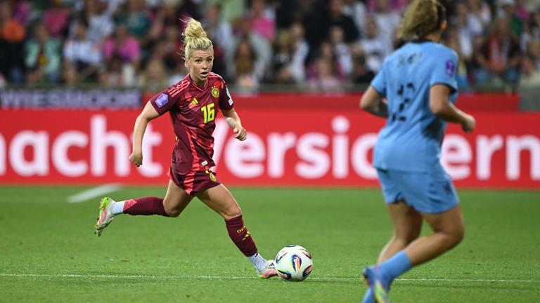 Linda Dallmann rennt mit dem Ball und schaut zu einer Gegnerin rüber auf dem Fußballplatz