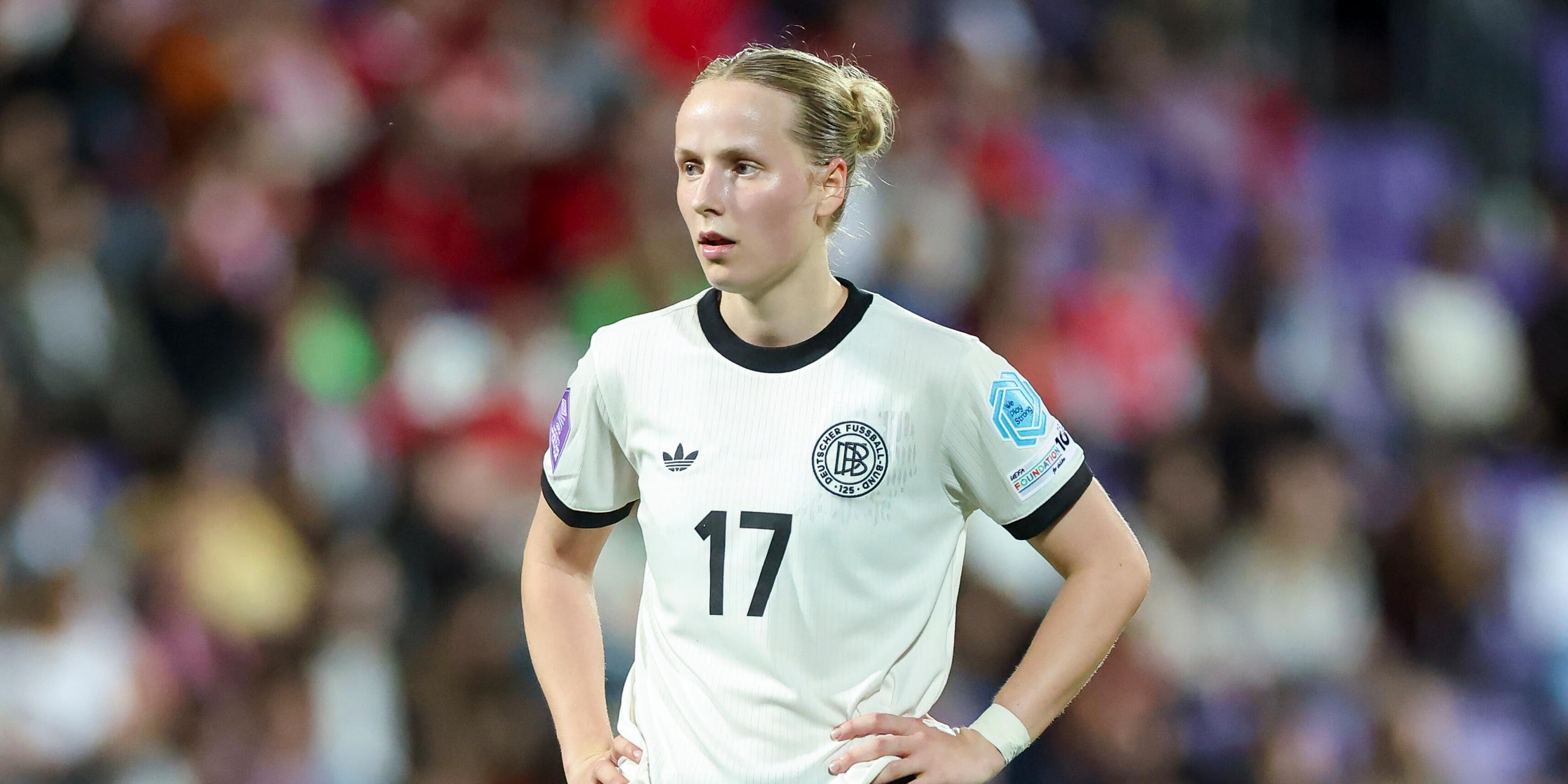 Franziska Kett hat die Arme in die Seite gestemmt und blickt nach vorne auf dem Fußballplatz