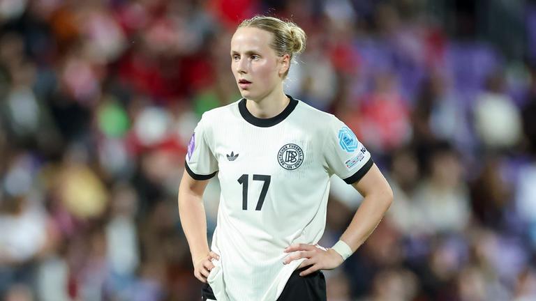 Franziska Kett hat die Arme in die Seite gestemmt und blickt nach vorne auf dem Fußballplatz
