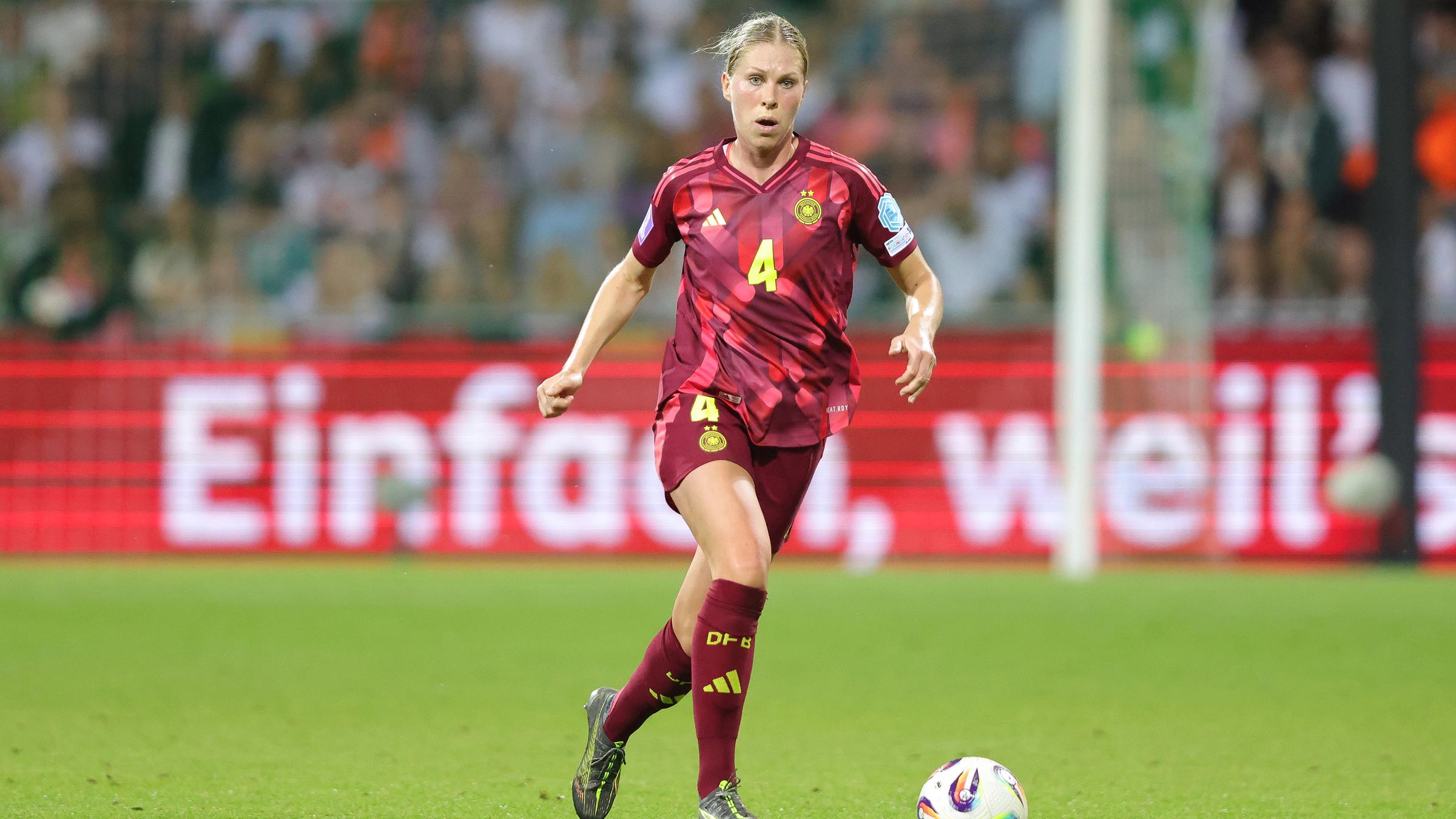 Rebecca Knaak ist am Ball und schaut zur Seite auf dem Fußballplatz