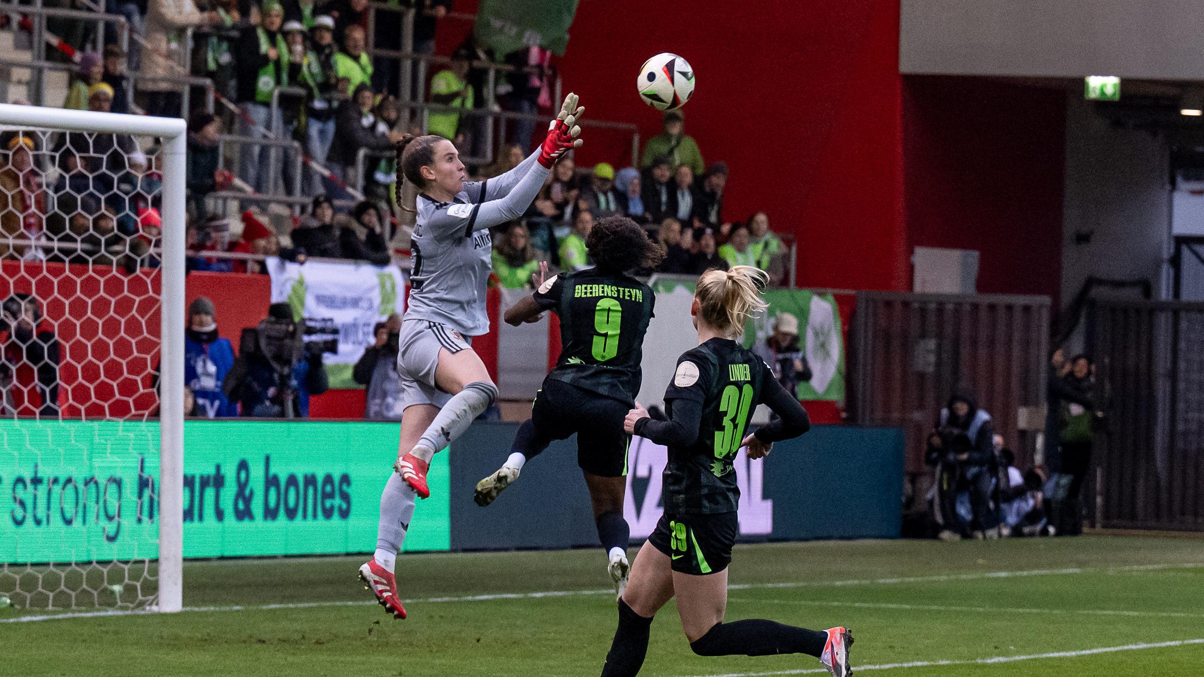 Ena Mahmutovic springt in die Luft, um den Ball zu fangen, sie ist vor dem Fußballtor