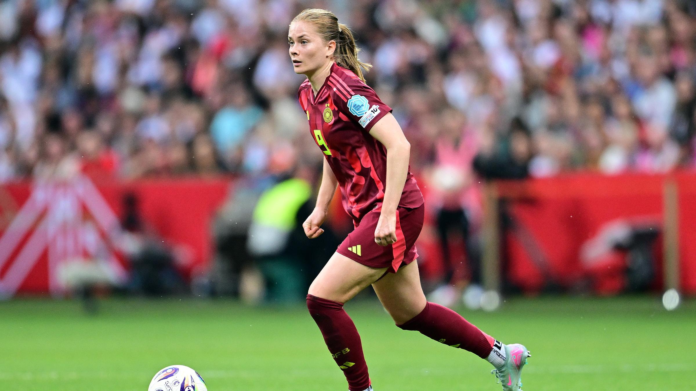Sjoeke Nuesken ist gerade am Ball und schaut nach vorne, sie ist auf dem Fußballplatz