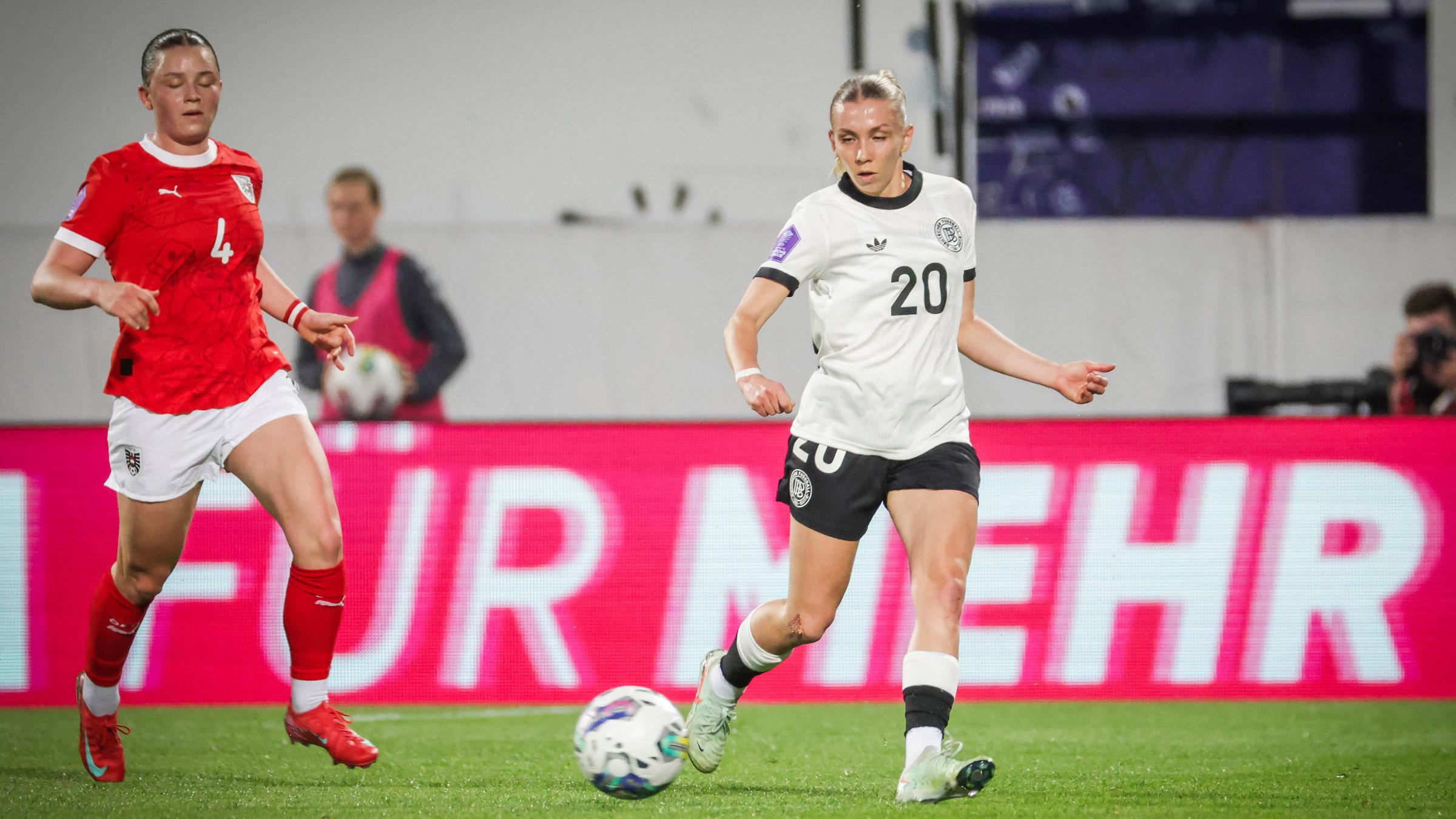 Elisa Senss rennt mit dem Ball vor ihrer Gegnerin auf dem Fußballplatz