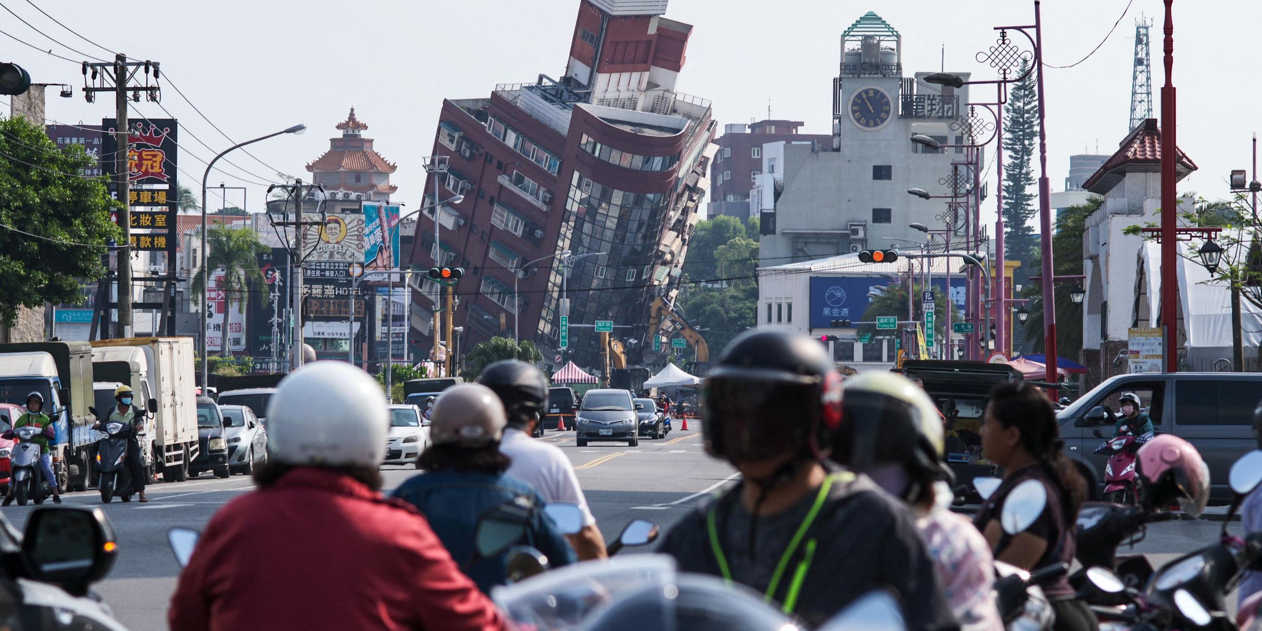 Viele Menschen schauen sich vom Erdbeben schiefe Häuser in Hualin in Taiwan an.