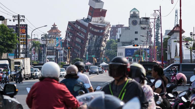 Viele Menschen schauen sich vom Erdbeben schiefe Häuser in Hualin in Taiwan an.