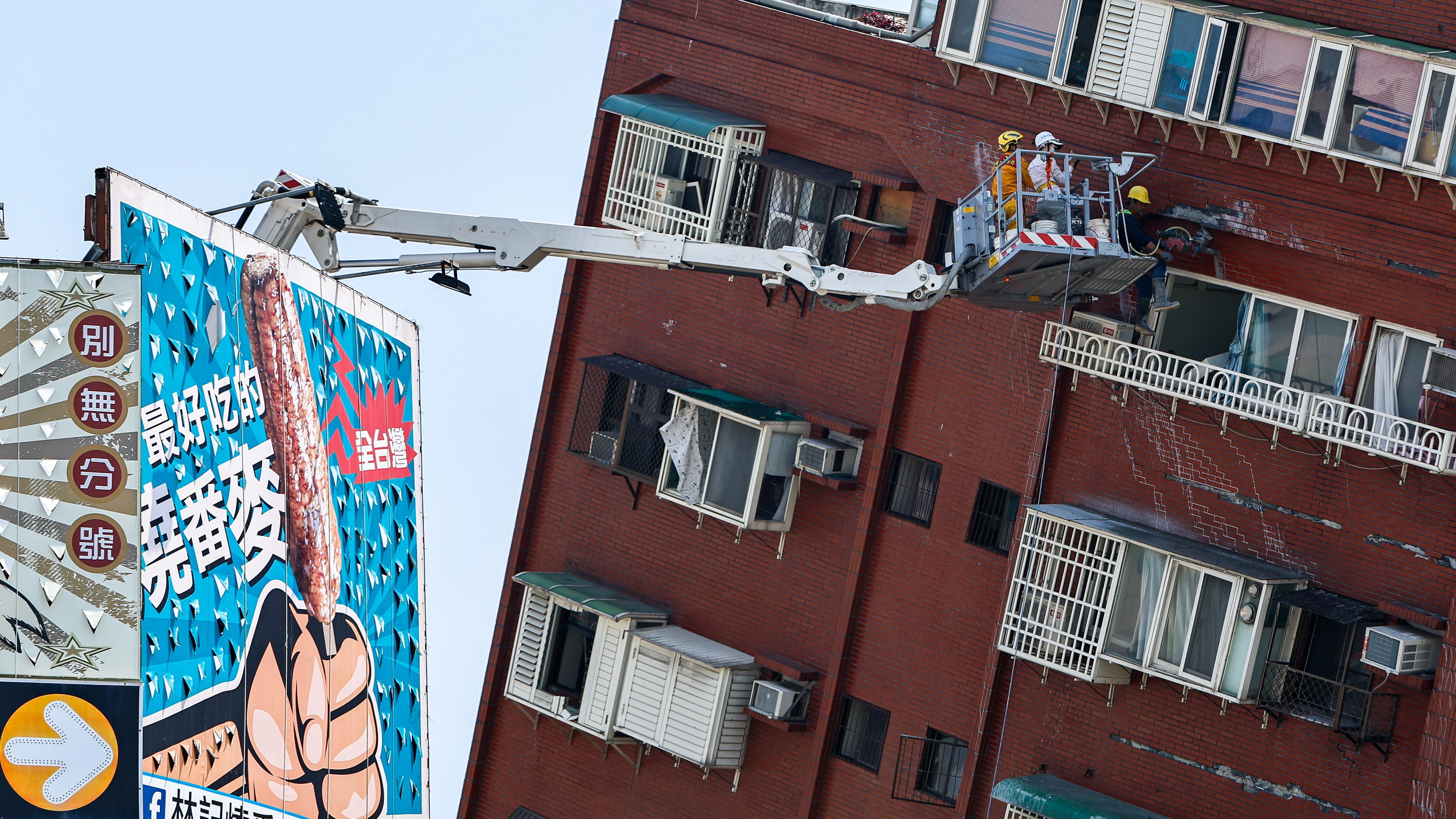 Ein Kran an einem sehr schiefen Haus nach dem Erdbeben in Taiwan