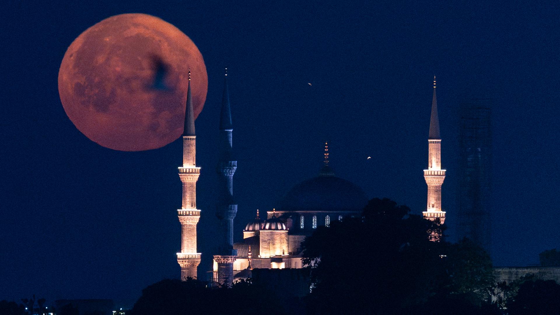 Der Erdbeermond zeigt sich hinter einer Moschee in Istanbul