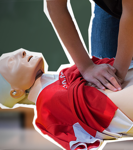 Ein junger Mensch übt eine Herzdruckmassage an einem 