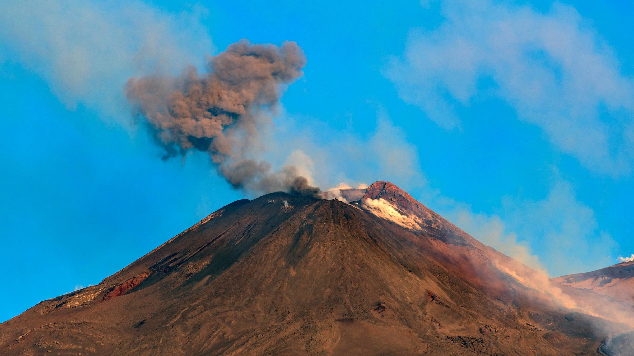 Aus dem Vulkan Etna steigt eine Rauchwolke aus.