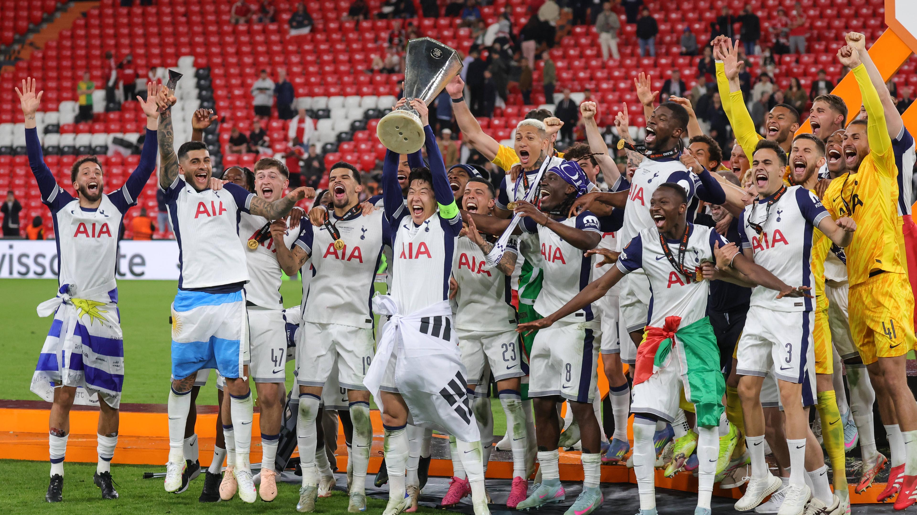 Die Fußballmannschaft Tottenham Hotspur jubelt und stemmt einen Pokal hoch